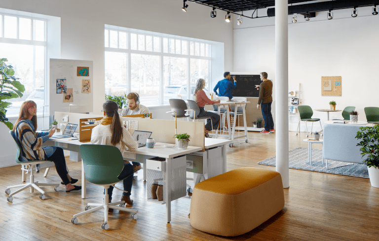 People working and communicating at their desks in a modern open office