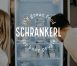 Two people looking in a fridge with the Schrankerl logo overlayed.