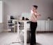 Woman Using Adjustable Height Standing Desk In Office For Good Posture